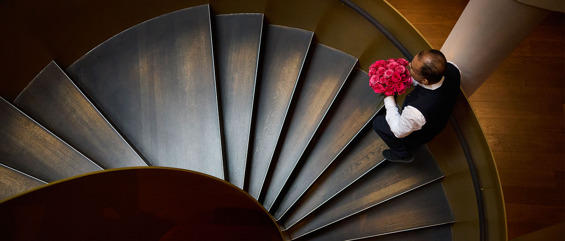 Page auf der Hoteltreppe mit Rosen